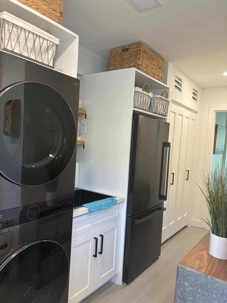 Modern laundry room with built-in cabinets, front-loading washer and dryer, and organized storage – clean and functional home laundry space design