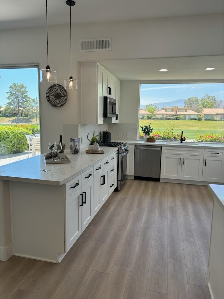 Modern kitchen with white shaker cabinets, quartz countertops, stainless steel appliances, and a large center island – stylish and functional home kitchen design