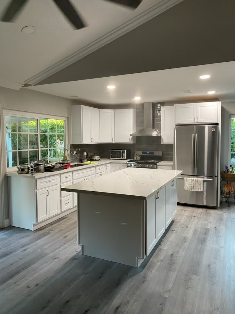 Contemporary kitchen with custom cabinetry, quartz countertops, integrated appliances, and a stylish breakfast bar – sleek and functional home cooking space